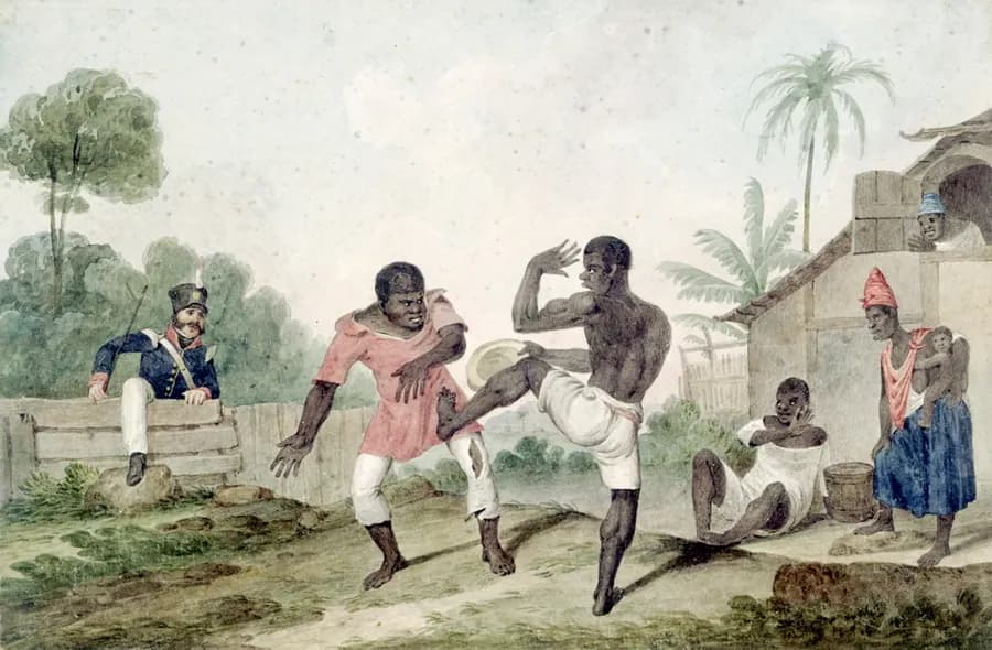 Capoeira performer inverted mid-kick inside a roda