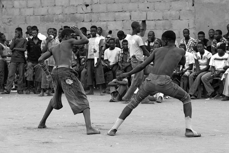 Dambe fighter with a bound striking arm in a forward stance